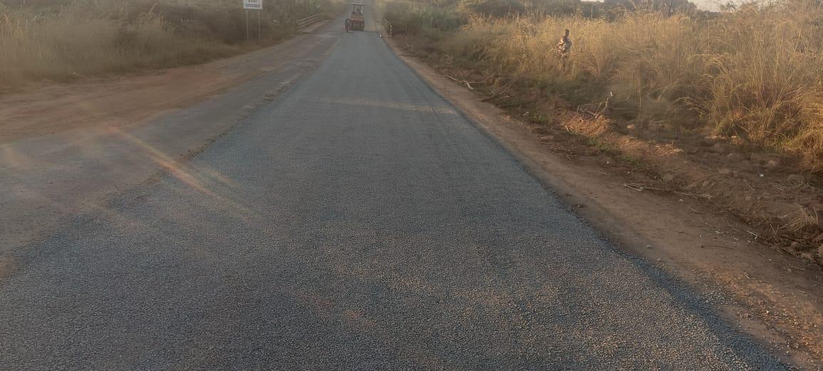 Estrada selada com rolo compactador ao fundo