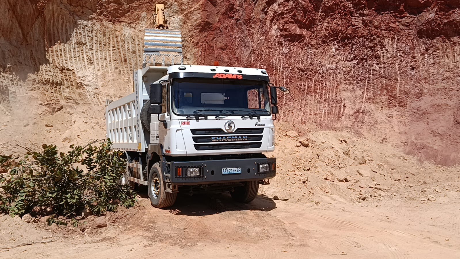 Basculante Shacman F3000 branco da Adam's Construções numa pedreira