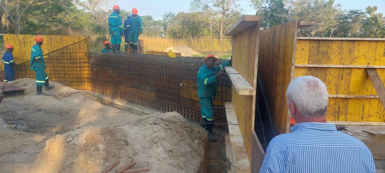 Responsável de obra a observar equipa a montar armadura e cofragem