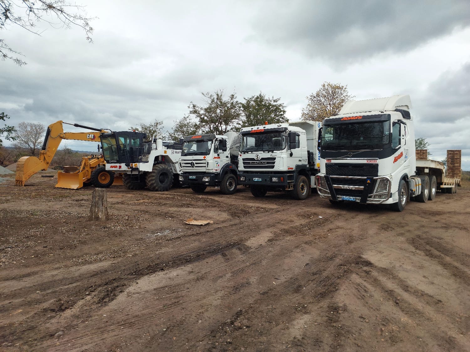 Máquinas e camiões da Adam's Construções alinhados no estaleiro