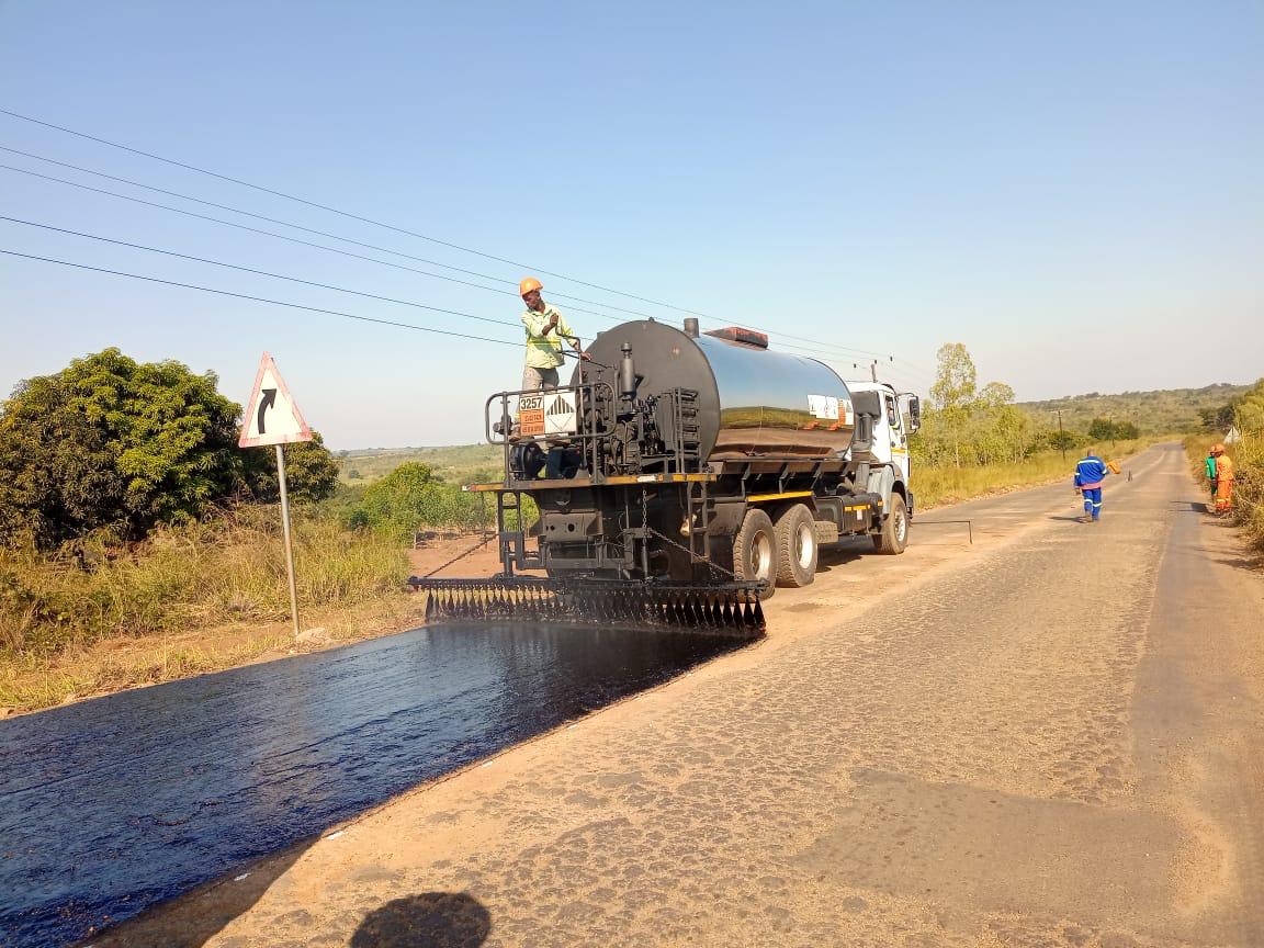 Camião cisterna a espalhar betuminoso sobre pavimento em obra